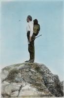 Dean with axe on mountain summit