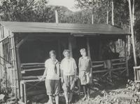 Three young people in front of a lodge