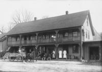 Pulled back image of a dry goods and grocery store with people on the porch