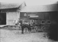 W.J. Metcalf Feed, Stable with man and stagecoach in front