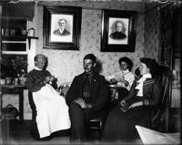 Family seated insde a house reading and knitting.