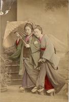 Two women posing in front of a mural of Mt Fuji